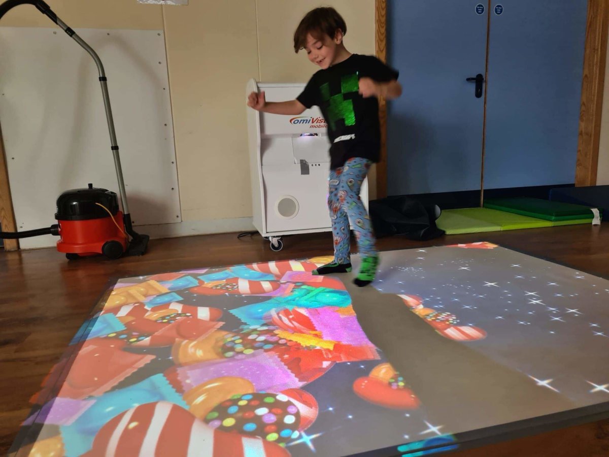 A young child playing on the interactive floor mat