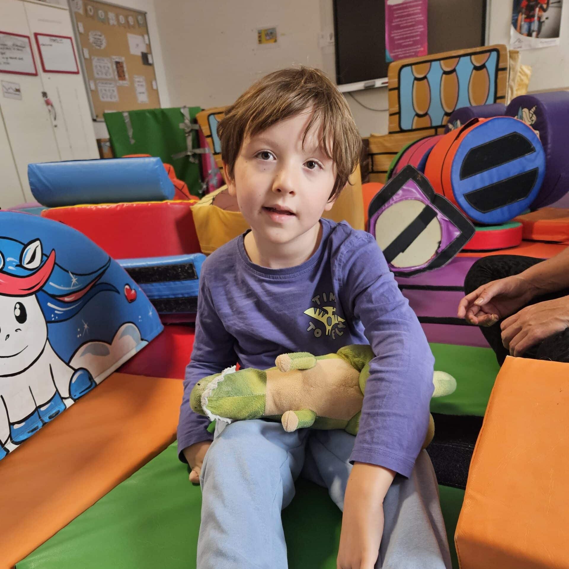 Young child sitting in a colourful softplay room