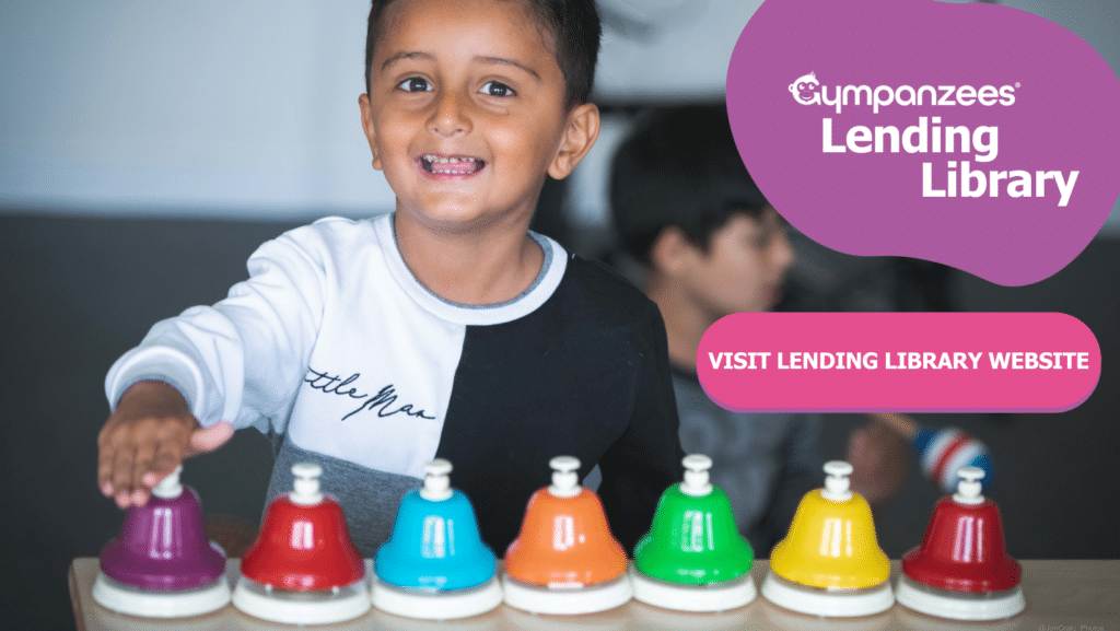 Child smiling in the camera while playing with bells