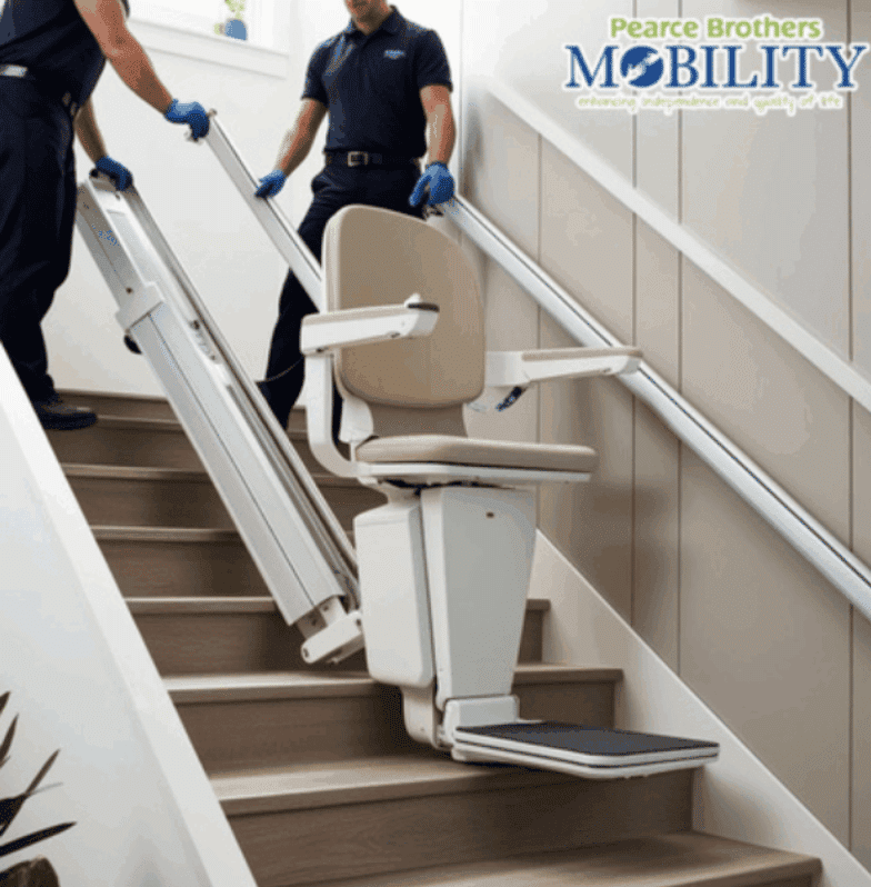 The image is of a stair lift on a lightly colour set of stairs with two people holding the frame at the top. In the top right corner there is a logo for, 'Pearce Bros Mobility.'
