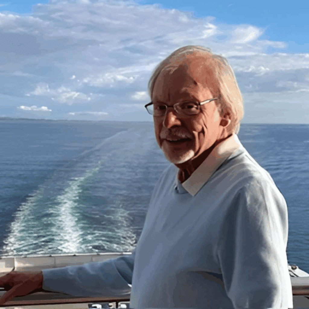 a person standing on the boat with large body of water in the background