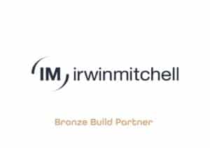 The image is of a logo with the initals 'IM', with little brackets around then it reads 'Irwin Mitchell.' With the words, 'Bronze Build Partner,' underneath.