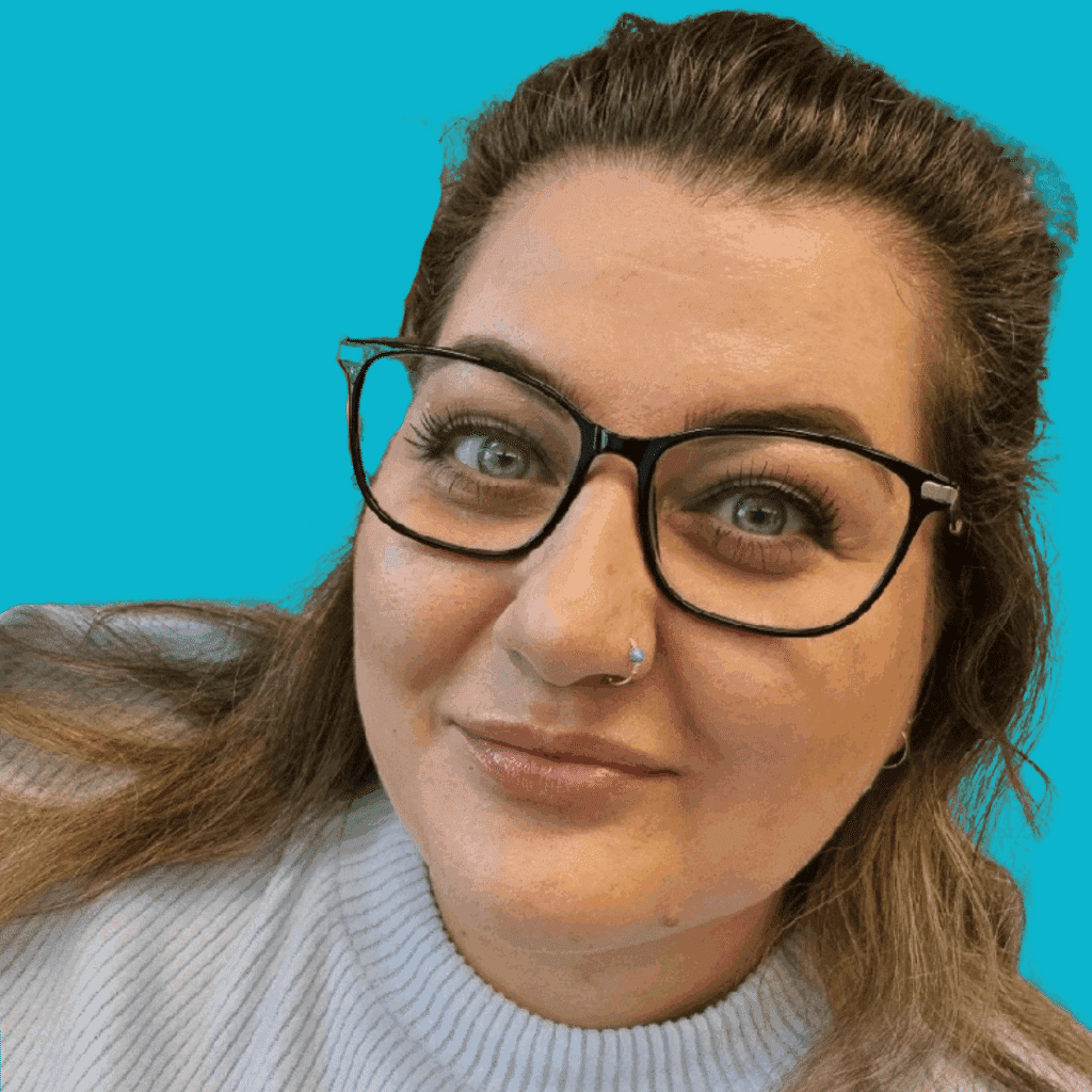 The image is of a woman with mid-length light and dark hair, wearing glasses, in a light top, from the shoulders up smiling into the camera, on a brightly coloured background.