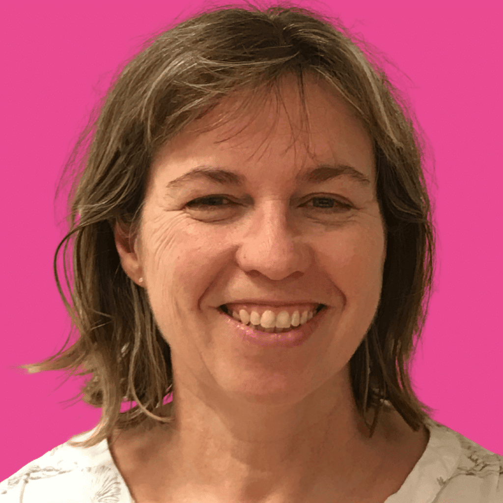The image is of a woman, from the shoulder up with short hair, a fringe and floral shirt on, with a bright background.