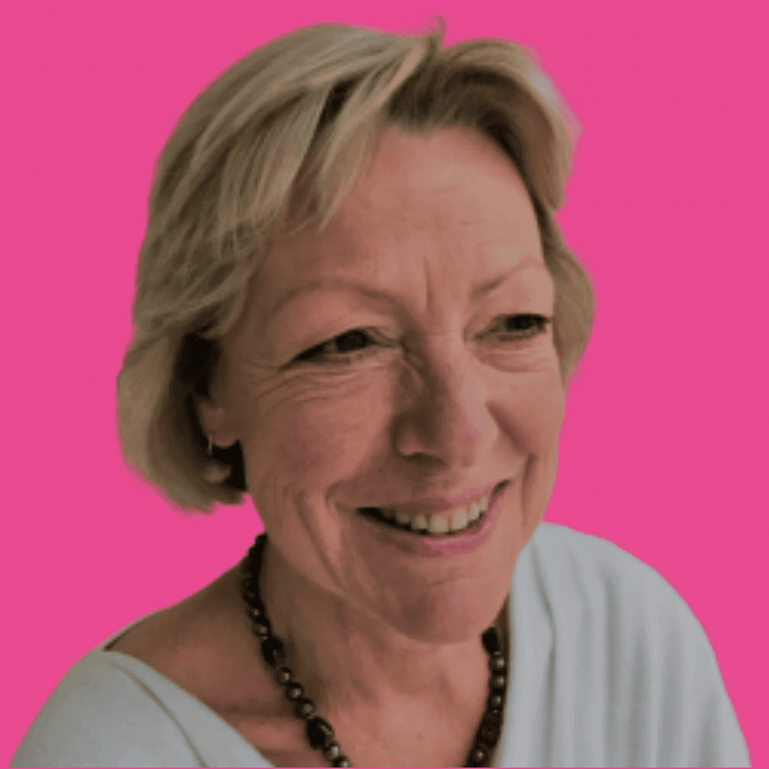 This circular image is of a woman, with lightly coloured hair, very short, from the shoulders up. In a light top, on a dimly lit background smiling to a point off camera.