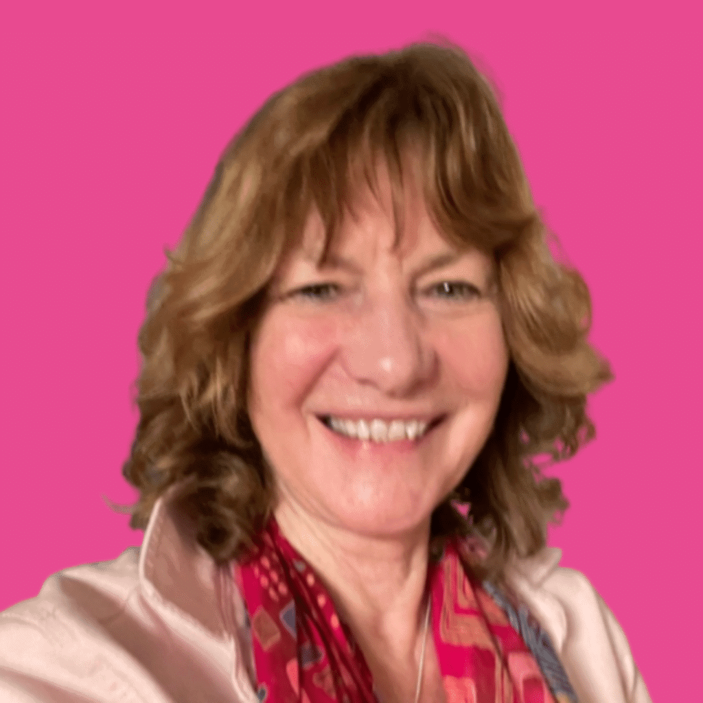 The image of of a woman, from the shoulder up with shoulder length hair and fringe, with bright colour shirt, smiling into the camera, with a bright background.