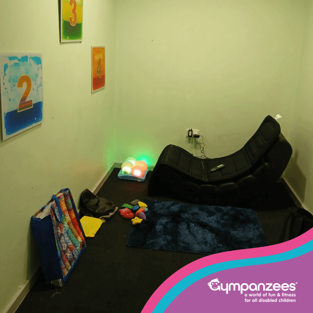 A dark sensory space with a vibrating chair, lights and tactile tiles on the wall.