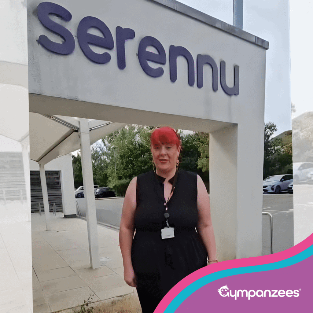 A woman stands outside Serennu Children’s Centre under the building sign, speaking to camera. Gympanzees branding overlay in the corner.