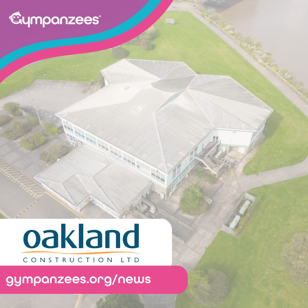 An aerial view of a large building surrounded by green lawns and paths. The image includes logos for Gympanzees and Oakland Construction Ltd, along with a URL: gympanzees.org/news
