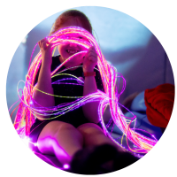 A young child looking through the colourful fibreoptic lights and smiling at Gympanzees sensory room