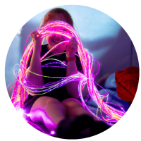 A young child looking through the colourful fibreoptic lights and smiling at Gympanzees pop up in a sensory room.